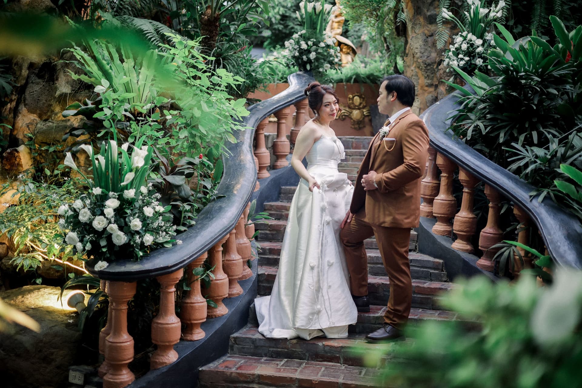 Bride and groom on a garden staircase